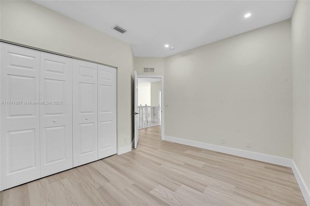 unfurnished bedroom featuring light hardwood / wood-style floors and a closet