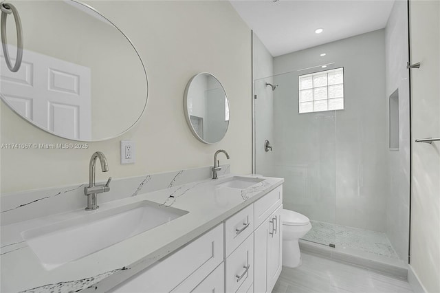 bathroom featuring vanity, toilet, and tiled shower