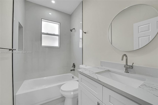 full bathroom featuring tiled shower / bath, vanity, and toilet