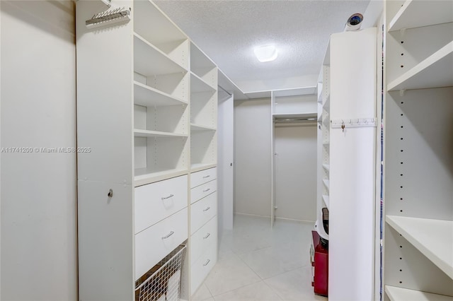 walk in closet with light tile patterned flooring