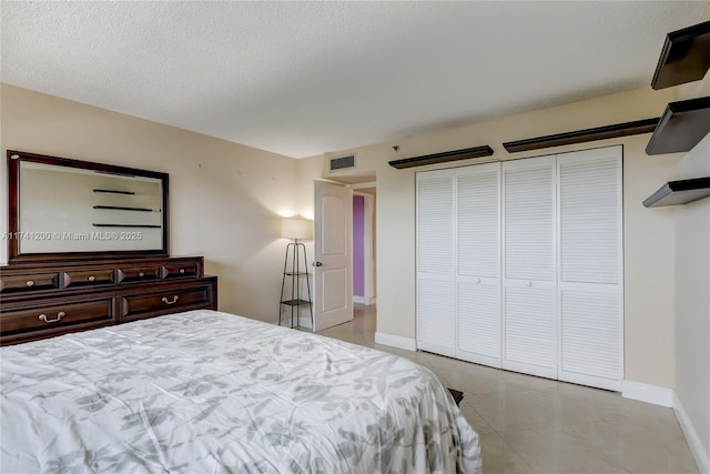 tiled bedroom featuring a closet and a textured ceiling