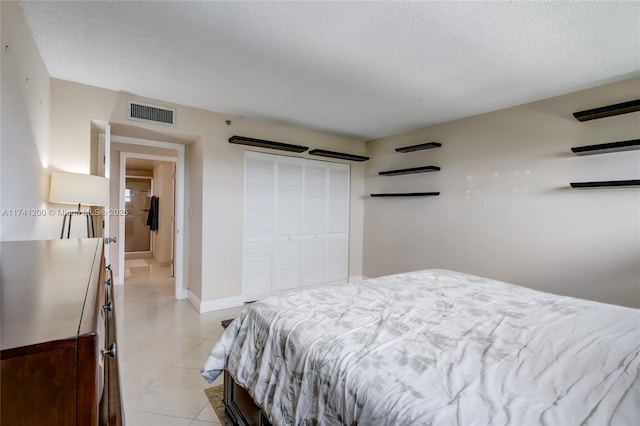 tiled bedroom featuring a closet and a textured ceiling