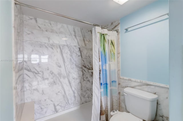 bathroom featuring tile walls, shower / tub combo, and toilet