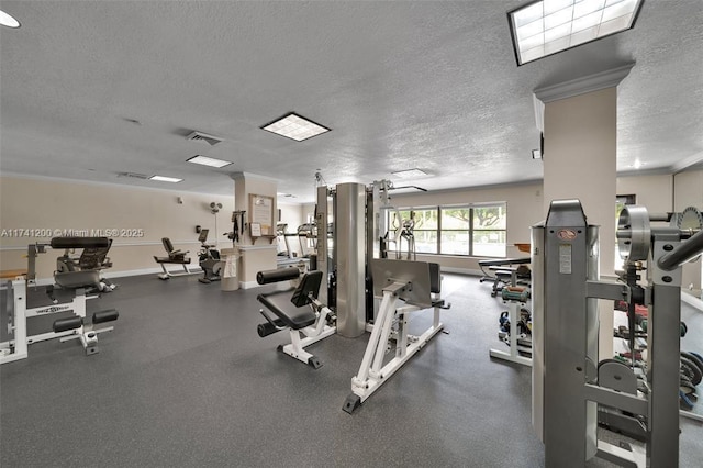 exercise room featuring a textured ceiling and ornate columns