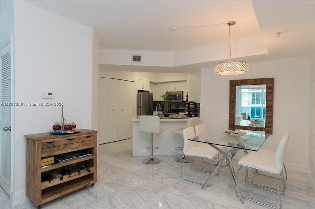 dining room featuring a raised ceiling