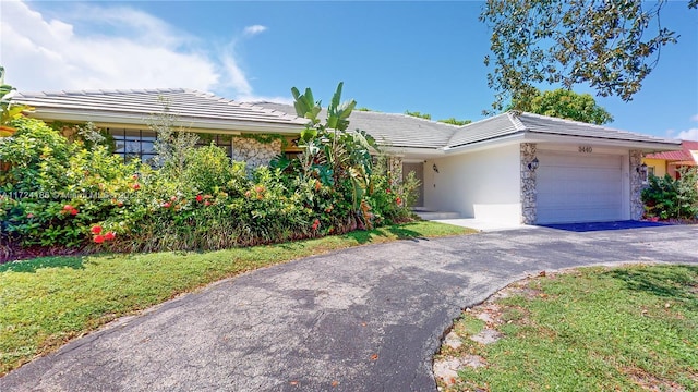 ranch-style home with a garage and a front yard