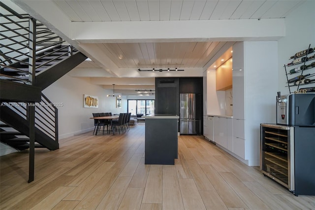 kitchen with track lighting, wooden ceiling, stainless steel refrigerator, and light hardwood / wood-style flooring