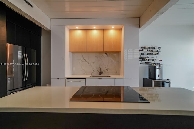 kitchen with sink, stainless steel fridge, backsplash, white dishwasher, and black electric stovetop