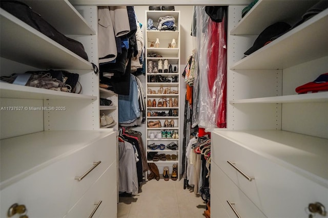 walk in closet with light tile patterned floors