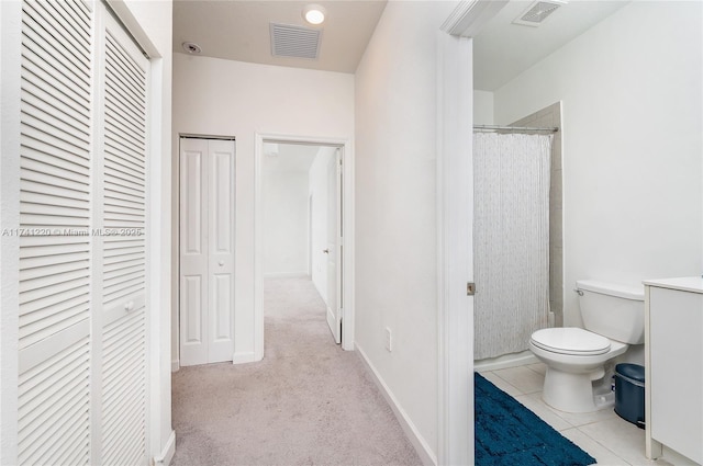 bathroom featuring tile patterned flooring, a shower with curtain, and toilet