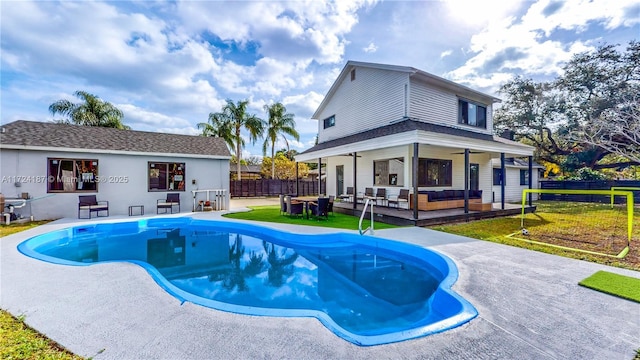 view of pool featuring ceiling fan, a yard, an outdoor hangout area, and a deck