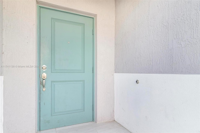 view of exterior entry with stucco siding