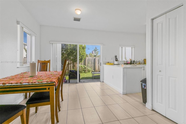 dining room featuring light tile patterned floors, plenty of natural light, visible vents, and baseboards