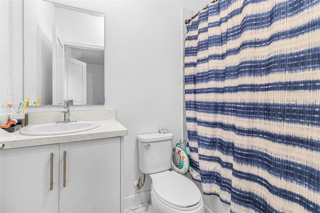 full bath featuring a textured wall, a shower with shower curtain, toilet, vanity, and baseboards