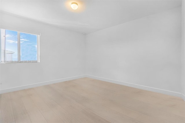 unfurnished room featuring light wood finished floors and baseboards