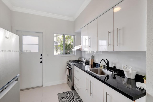 kitchen with sink, light tile patterned floors, appliances with stainless steel finishes, ornamental molding, and white cabinets