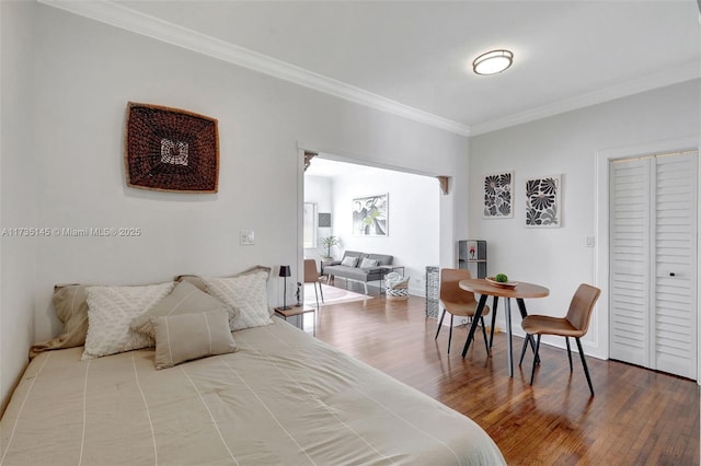 bedroom with ornamental molding and hardwood / wood-style floors