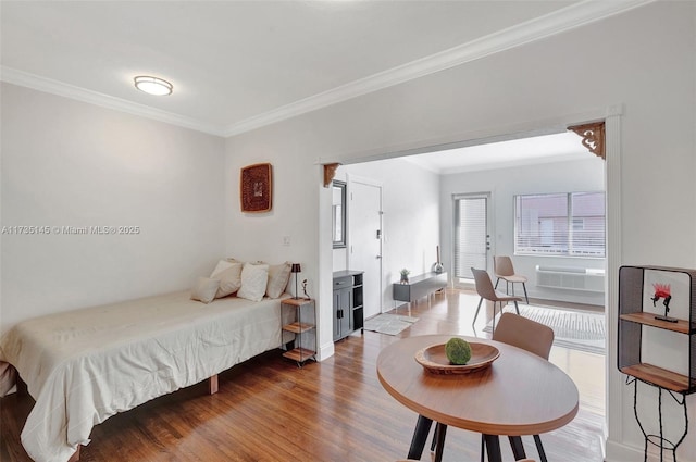 bedroom with crown molding and hardwood / wood-style floors