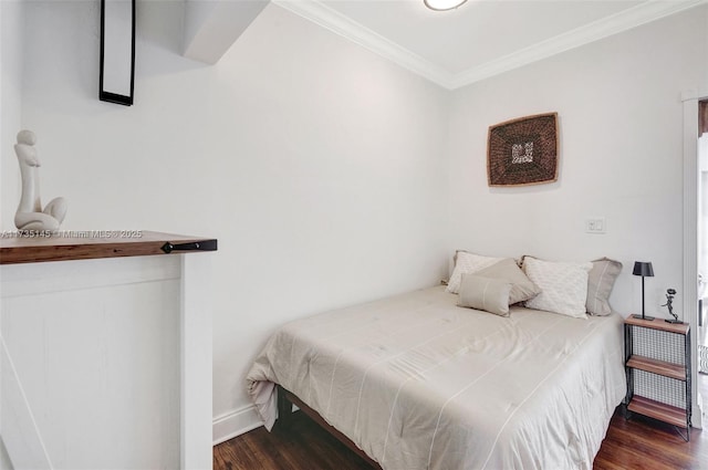 bedroom with ornamental molding and dark hardwood / wood-style floors