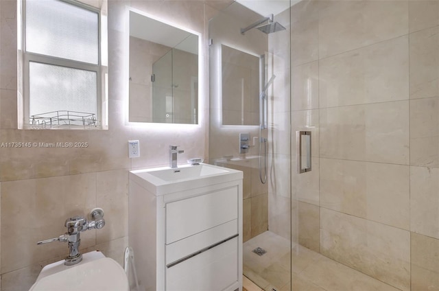 bathroom with tile walls, vanity, and a shower with shower door