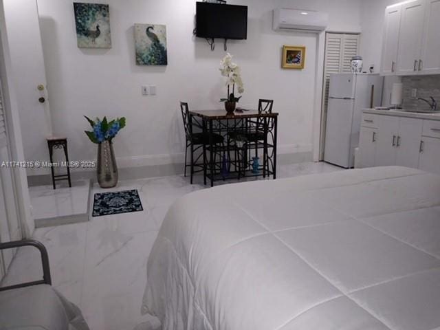 bedroom featuring white refrigerator and a wall mounted air conditioner