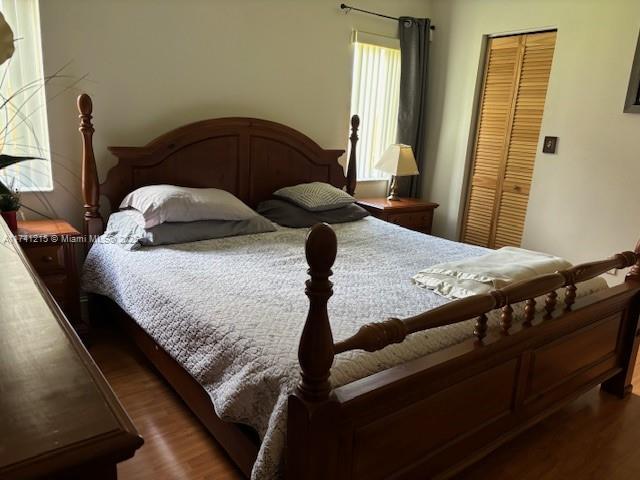 bedroom featuring dark hardwood / wood-style flooring and a closet