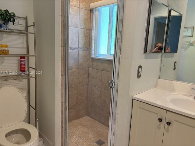 bathroom with walk in shower, vanity, and toilet