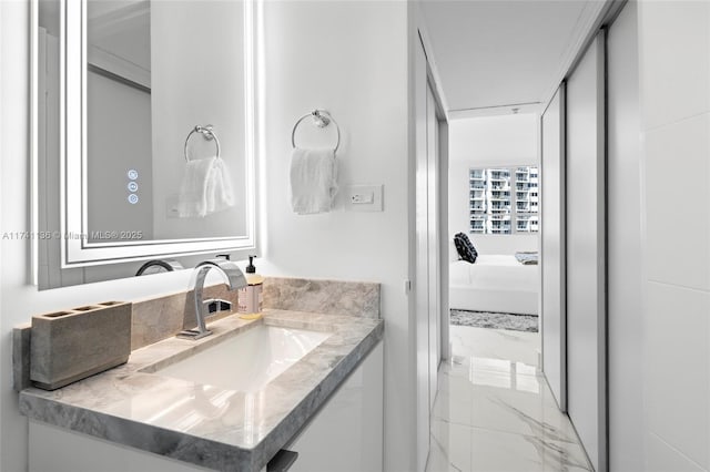 bathroom featuring ensuite bathroom, marble finish floor, and vanity