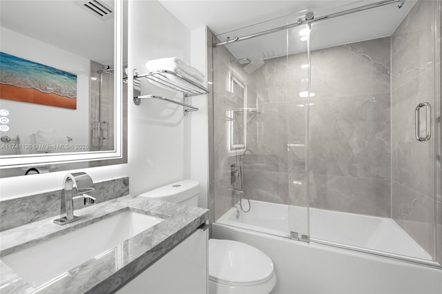 full bath featuring visible vents, combined bath / shower with glass door, vanity, and toilet