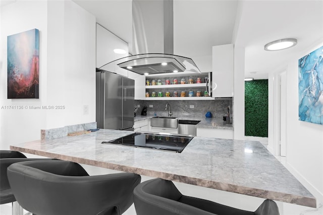 bar with tasteful backsplash, island range hood, wet bar, stainless steel appliances, and a sink