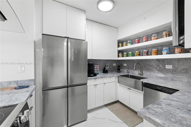 kitchen featuring marble finish floor, open shelves, tasteful backsplash, appliances with stainless steel finishes, and a sink