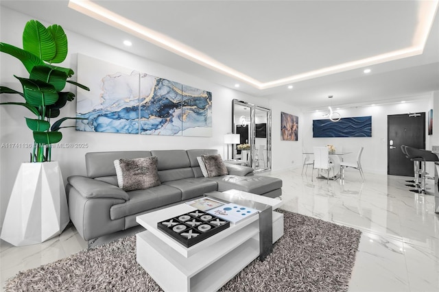 living room with marble finish floor, a tray ceiling, and recessed lighting