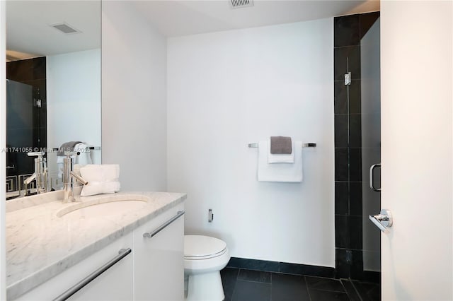 bathroom with tile patterned floors, vanity, toilet, and a shower with shower door