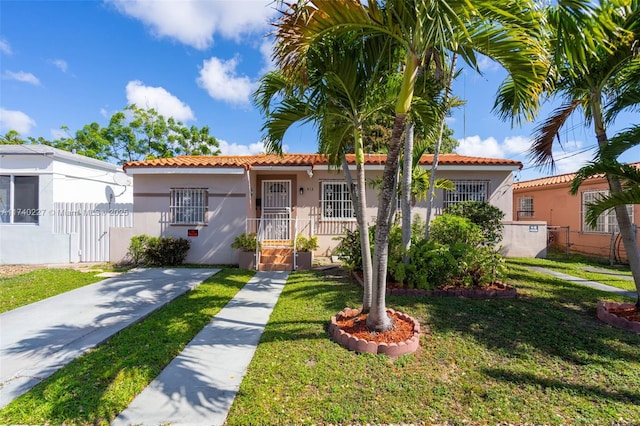 mediterranean / spanish-style home with a front lawn