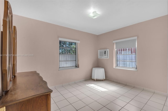 unfurnished room featuring light tile patterned flooring and a wall unit AC