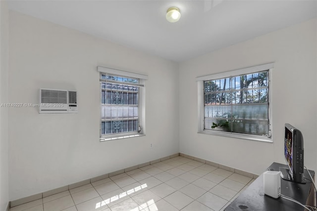 empty room with a wall mounted air conditioner and light tile patterned floors