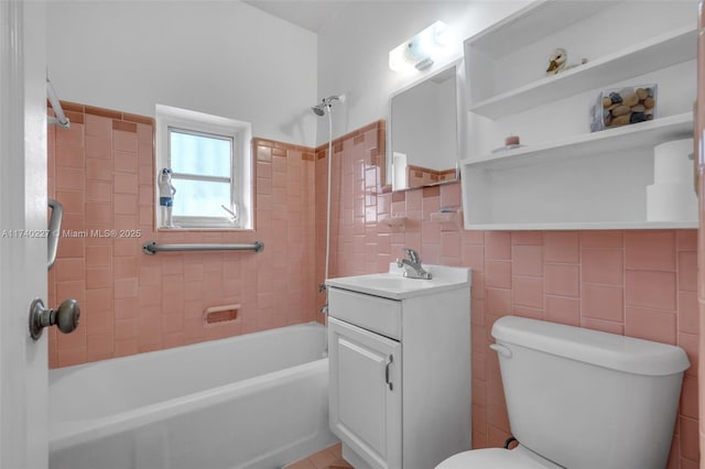 full bathroom featuring tile walls, vanity, tiled shower / bath combo, and toilet