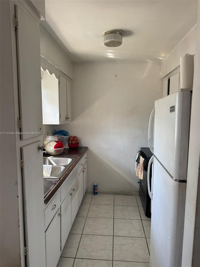 kitchen with white cabinetry, white fridge, sink, and electric stove