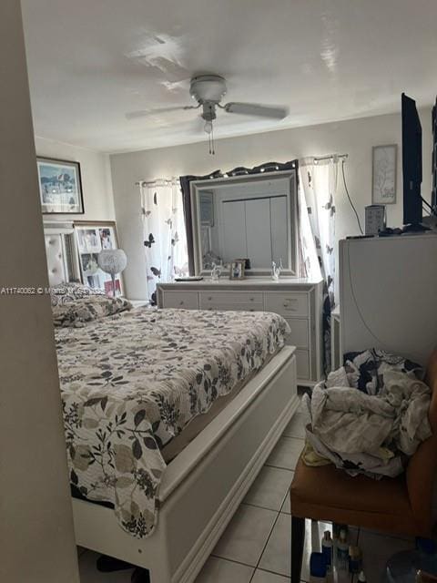 tiled bedroom featuring ceiling fan