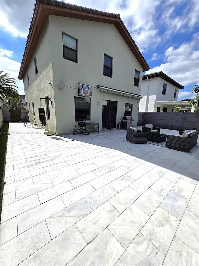 back of house featuring an outdoor living space and a patio