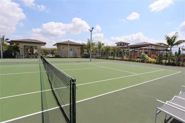 view of tennis court featuring a playground