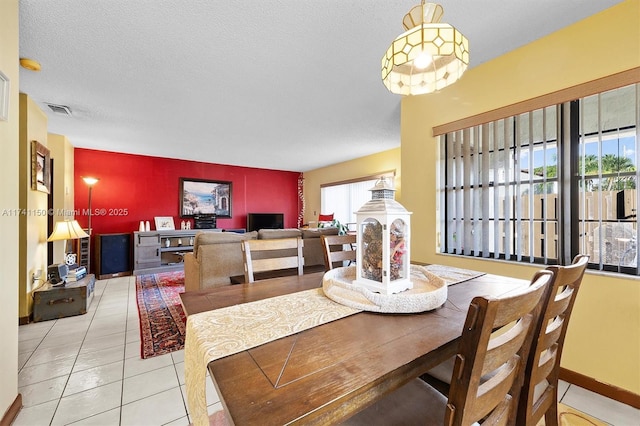 tiled dining area featuring a textured ceiling