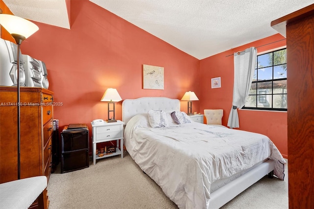 bedroom featuring carpet floors, vaulted ceiling, and a textured ceiling