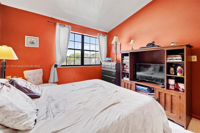 bedroom featuring vaulted ceiling, a textured ceiling, and carpet