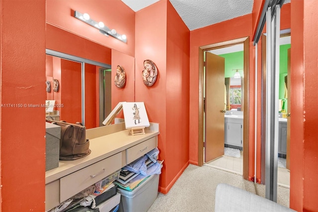 corridor featuring light carpet and a textured ceiling