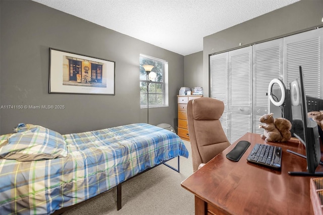 bedroom featuring a closet, a textured ceiling, and carpet flooring