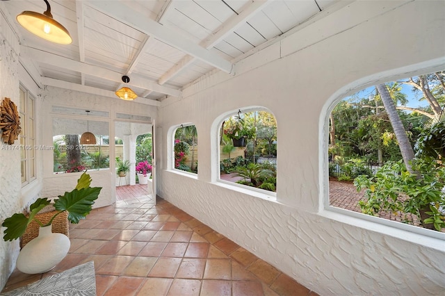 sunroom with plenty of natural light, wooden ceiling, and beamed ceiling