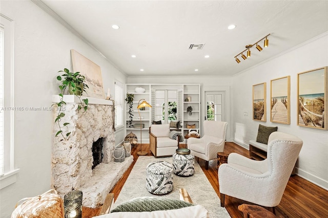 living room with dark wood-type flooring, ornamental molding, and a premium fireplace