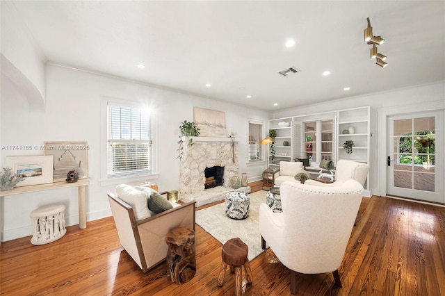 living room with a stone fireplace and hardwood / wood-style floors