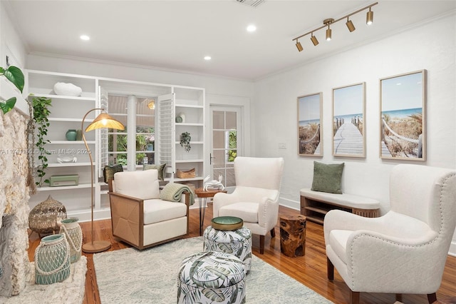 sitting room featuring crown molding, rail lighting, and hardwood / wood-style floors